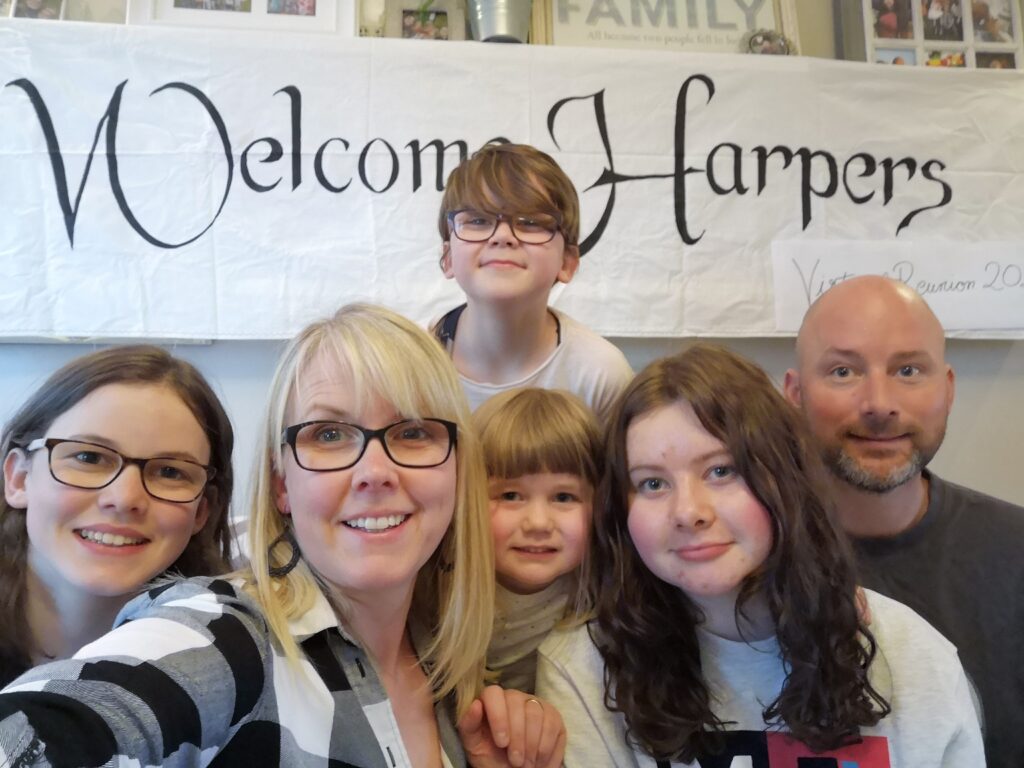Ellie, Patricia, Lauren, Abbie, Hannah and David Harper welcome other Harper's to the virtual reunion with a banner