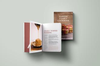 the harper family cookbook lays open on a spread showing a sticky toffee putting recipe and a photo of caramel sauce being poured on a pudding, behind it the cover of the harper family cookbook with an image biscuits neatly stacked and wrapped in gingham